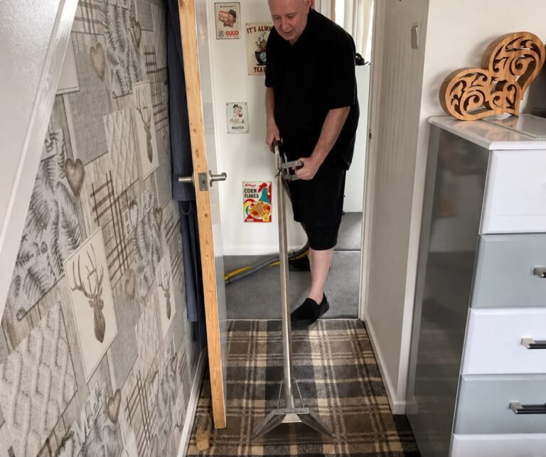 Russell working in a hallway with a cleaning wand