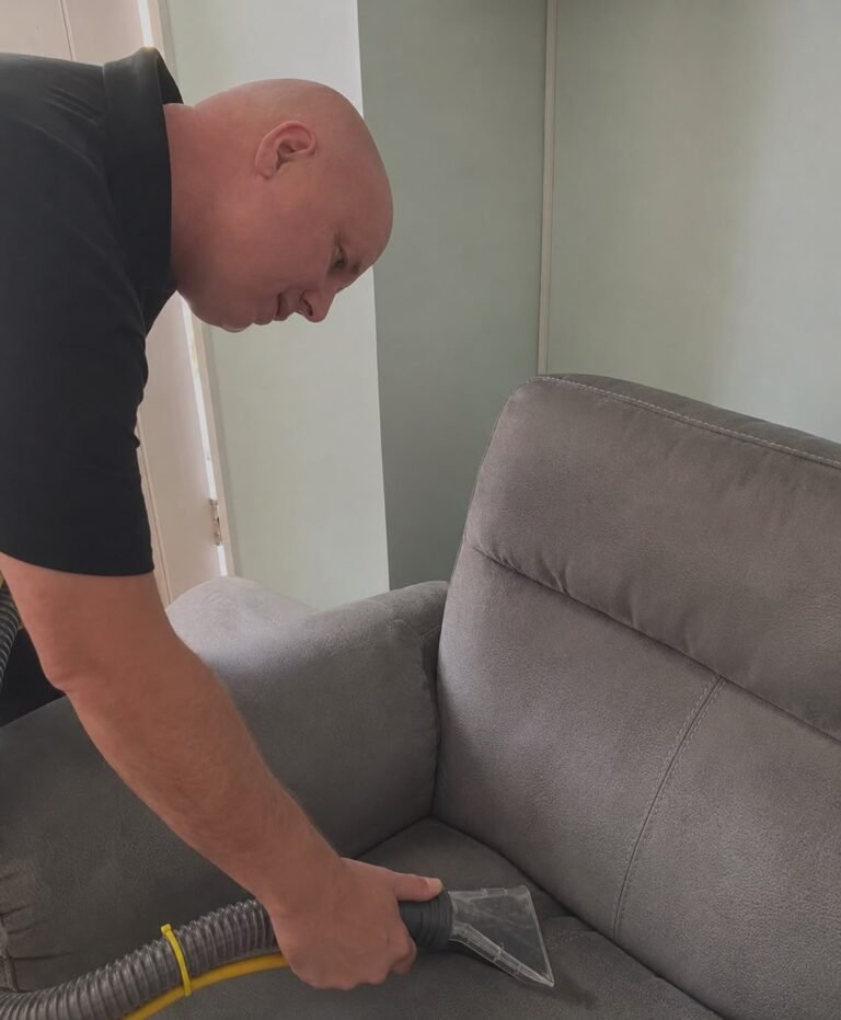 Russell cleaning a grey fabric sofa