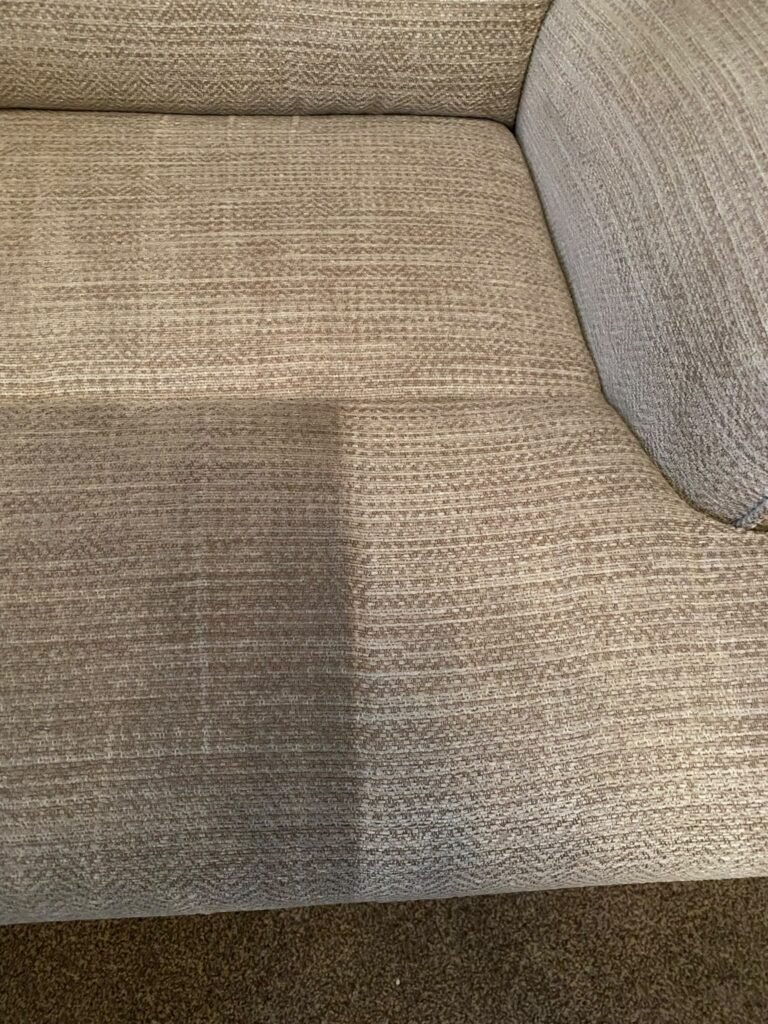 Beige fabric sofa seat half cleaned